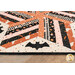 A super close up on one of the appliqué bats, demonstrating details on the orange, pink, black, and cream fabrics.