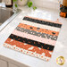 The completed Dry Ideas project, colored in Halloween fabrics from the Purrs & Boos collection by Moda Fabrics, staged on a white marbled kitchen counter with coordinating décor.