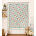 The completed Star of the Show Baby Quilt, colored in serene shades of blue, pink, and cream fabrics from the Woodland Heart collection by Northcott Fabrics, staged on a cream shiplap wall in a nursery with coordinating stuffed animals and décor.