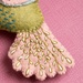 Close-up of the felted pink tailfeathers with stitched details on a pink background.