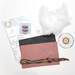 The kit supplies outside of the box, featuring the felt, floss, filling, and printed instruction sheets.