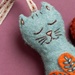 Close up on the cat's serene face, demonstrating embroidery details.