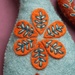 Close up on the orange flower, demonstrating embroidery details.