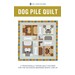 front cover of the Dog Pile Quilt featuring the a quilt with 4 dogs, dog bones, and a colorblock border.