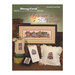 Cover of Summer in the Village cross-stitch book featuring framed artwork and decorative items.