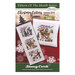 Front cover of the cross stitch pattern with the finished projects displayed on a red and cream snowflake-covered background.