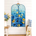 The completed project colored in a vibrant blue poppy panel, staged on a hanger against a white shiplap wall with coordinating flowers and décor.