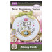 Front cover of the cross stitch pattern with the finished project shown in a hoop with a green bow.
