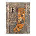 Front cover of the All Hallow's Eve Stocking cross stitch booklet finished on an orange cloth hung on a wooden background.