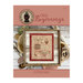 Front page of the New Beginnings cross stitch pattern finished in a wooden frame next to quaint house supplies and a birds nest.