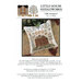 Front of pattern showing the completed cross stitch on a small ornament pillow staged on a floral fabric.