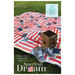 American Dream quilt pattern cover showing a red, white, and blue patchwork quilt with repeated flag-inspired blocks displayed on grass.