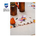 A super close up on the stitched witch, staged with bright orange lantern fruit and coordinating glasses.. 