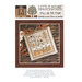 Front of pattern showing the completed cross stitch on a small ornament pillow staged on a table by autumnal sprigs.