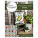 A finished pattern as a cushion displayed with garden equipment and plants.