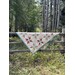 Quilted triangular banner draped over a wooden fence in a wooded area.