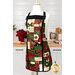 The completed Charm Squares Apron, colored in red, green, cream, and gold metallic fabrics from the Poinsettias at Christmas collection by Jennifer Bosworth for Riley Blake Designs, staged on a mannequin in an airy kitchen space.