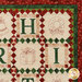 A closer look at the quilt, showing details on the appliqué letters H and I as well as the hand embroidered wreath and present.