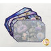 Fanned out stack of four floral-patterned placemats made of panels in purple and blue fabrics; the template sits on the topmost placemat.