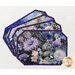 Fanned out stack of four floral-patterned placemats made of panels in purple and blue fabrics.