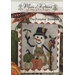 Cross-stitch pattern cover showing a snowman with pumpkins and a bird on a plaid background.