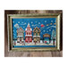 Finished pattern in an ornate frame on a wooden plank floor.