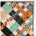 A close up on the upper right corner of the quilt, showing details on the binding as well as demonstrating fabric prints and color details.
