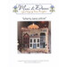 Front cover of the Liberty Lane pillow cross stitch pattern with the finished pattern in front of a lit candle bunch.