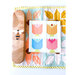 A tulip block staged on a quilt.