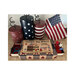 Photo of the finished United We Stand Sewing Box cross stitch pattern opened up to show a pinkeep and scissors in front of an American flag and other patriotic décor.