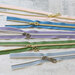 Five zipper pieces in various colors arranged horizontally, showing their coordinating novelty zipper pulls.