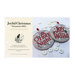 The front of the Joyful Christmas Ornaments 2025 pattern showing the completed ornaments on a swatch of gray fabric amongst scattered buttons.