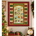 The completed 12 Days of Christmas Countdown Calendar Quilt, colored in rich holiday shades from the 12 Days of Christmas collection by Nancy Halvorsen for Benartex, hung on a neutral wall beside a wreath and decorated tree. 