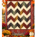 The completed Ridiculously Easy Jelly Roll Quilt, colored in warm, rustic prints from the Bountiful Blessings collection by Henry Glass Fabrics and staged on a red barn wall among baskets of coordinating flowers.