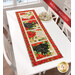 The completed Reason for the Season Table Runner, colored in red, cream, and black fabrics from the Poinsettia Radiance collection from White Owl Textiles, staged on a white table; a red banner in the upper right corner reads "Backing Included!"