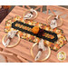 The completed Easy Striped Table Runner, colored in warm, autumn themed prints from the Give Thanks collection by Timeless Treasures Fabrics, staged on a warm wooden table with coordinating décor and four table settings with plates and napkins.