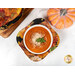A top down shot of one of the cozies, demonstrating function by holding a bowl of tomato bisque with cheese and basil.