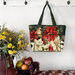 The completed tote made with a sophisticated poinsettia and bird panel, staged against a wall with coordinating flowers.