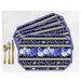 Four placemats fanned out and colored in a black, blue, and gold floral print, staged with gold utensils on a white background.