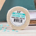 A roll of the finishing tape in its packaging staged on a craft table with scattered décor.