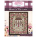 front cover of the Home is Wherever cross stitch pattern featuring a white brick house surrounded by florals.