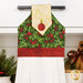A close up on the top section of the towel, showing details on the mistletoeA close up on the fabric stripe through the bottom of the towel. fabric as well as the fabric button.