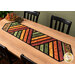 The completed Greased Lightning Table Runner colored in warm fall fabrics from the Harvest Beauty collection by Benartex, staged on a warm wooden table.
