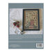 Back cover of the Strawberry Fields Forever cross stitch pattern finished in a black frame next to stitching supplies.