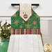 A close up on the top section of the towel, showing details on the ornament fabric as well as the fabric button.