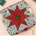 A close up, top down shot of the Folded Star Pin Cushion Kit, staged on a wooden surface.