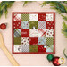 The completed Fusible Grid Hot Pad colored in wintry prints from the Chilly collection by Moda Fabrics, staged on a wooden surface with a wooden spoon.