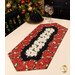The completed Easy Striped Table Runner, colored in black, red, and cream fabrics with gold metallic accents from the Merry Christmas 2026 collection by Timeless Treasures, staged on a cream table with coordinating glasses and décor.