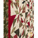 A close up on the patchwork of the quilt, demonstrating fabric colors and print details as well as top quilting effects.