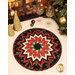 The completed Point of View Kaleidoscope Folded Star Table Topper colored in black, red, and cream fabrics with gold metallic accents from the Merry Christmas 2026 collection by Timeless Treasures, staged on a cream table with coordinating glasses and décor.
